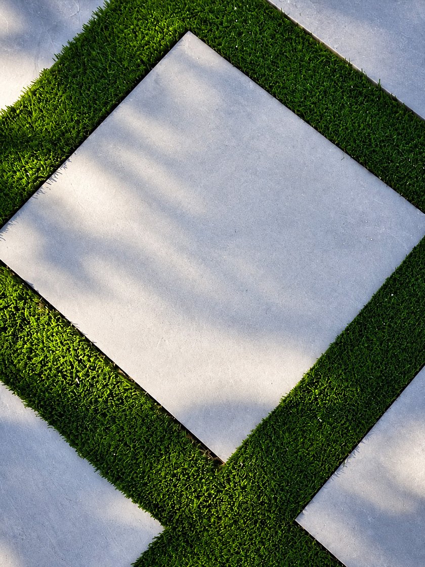 Artificial turf strips set between square concrete pavers in a diamond pattern