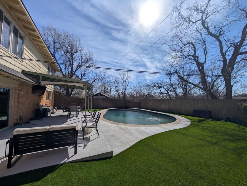 New concrete pool deck and patio curving into artificial turf in an Oklahoma City backyard