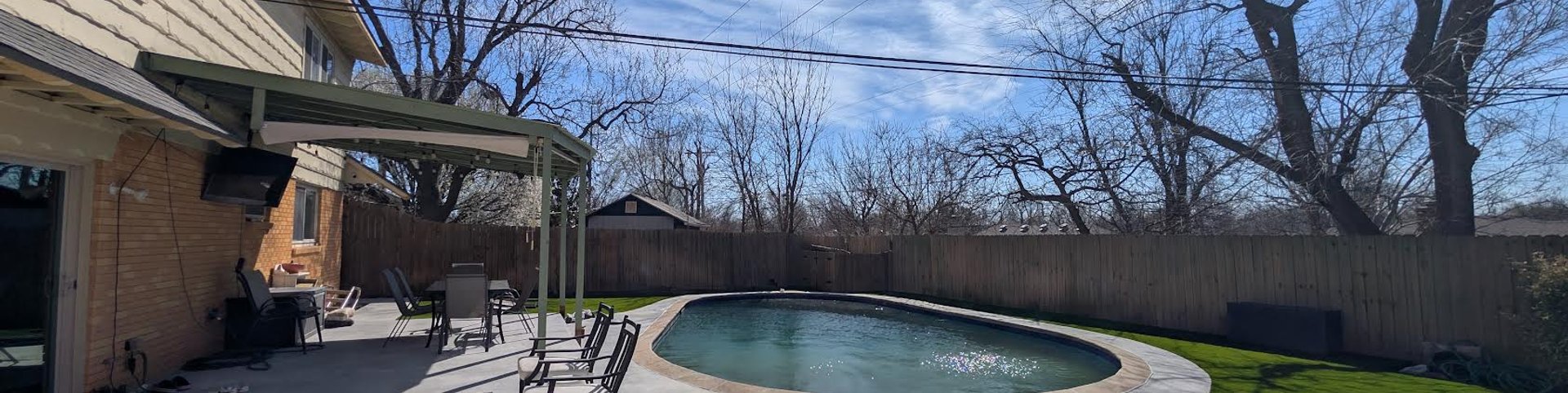 New concrete pool deck and patio curving into artificial turf in an Oklahoma City backyard