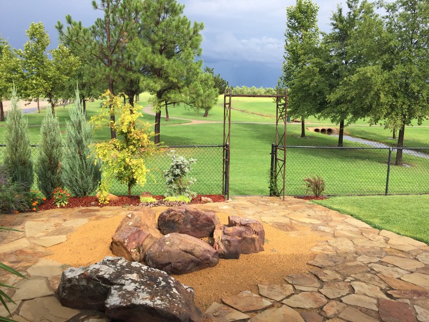 Flagstone patio with boulder seating on a crushed granite pad, looking out over a golf course